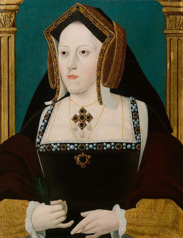 Portrait of Catherine de Medici, daughter of Ferdinand & Isabella of Spain and wife of Henry VIII, wearing a grand black gown edge with gold and pearls, pendants with a cross and black stones, and a hat that looks like her head was jammed inside a Monopoly hotel, then covered with gold.