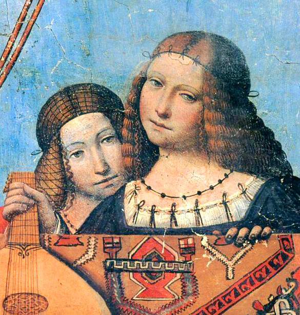 Painting of Isabella and Beatrice d’Este together. The sisters are both teenaged girls in Renaissance gowns, leaning near each other as if one is embracing the other. Both have their hair semi-loose, with ribbons or snoods holding it with loose netting, and wear necklaces of black beads and gowns of dark blue with many decorative ribbons showing from the edges of the white chemises underneath. The one in the foreground (probably Isabella) holds a lute.