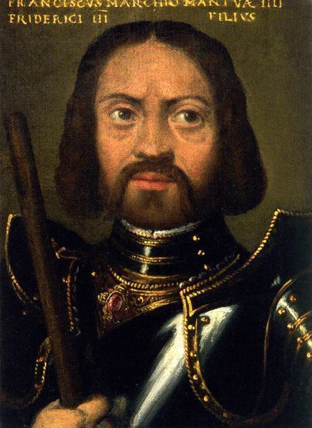 Portrait of Francesco Gonzaga. His expression is grim and severe. He has dark brown hair down to his chin and a dark and full moustache and beard, and wears gleaming armor edged in decorative gold. He holds a strong wooden rod in his hand, which could be a spear or the handle of a weapon, or simply a stick to beat servants with.