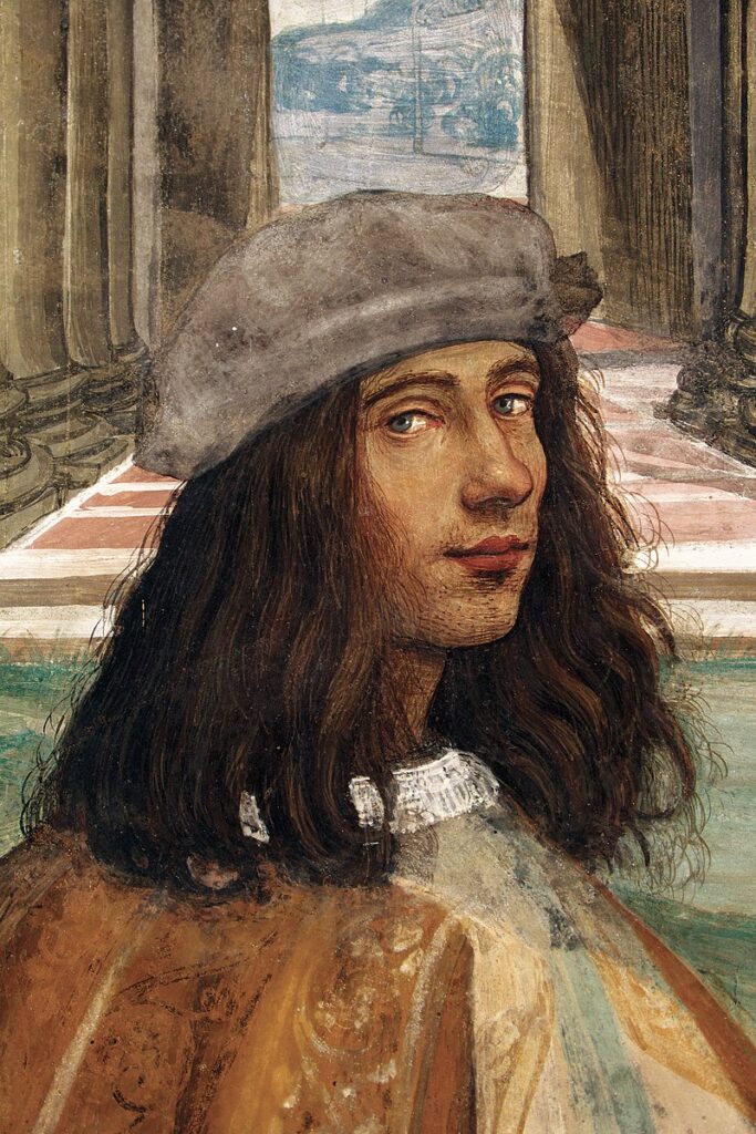 Portrait of Sodoma looking like a typical gorgeous Renaissance youth, with dark brown hair down to his shoulders and a little cap. He's smiling.