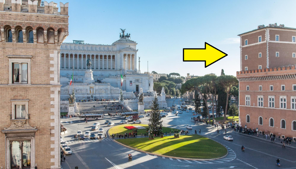 Photo of Piazza Venezia, one can see the huge white Vittorio Emanuelle monument in the center, often called the "Wedding Cake" or the "Typewriter" by locals who consider it overly huge and silly. To the right is a big brick battlemented palace, with an arrow pointing to it indicating that it's Paul's Palazzo Venezia.